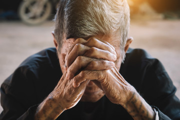 senior man covering his face with his hands.vintage tone