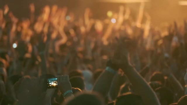 Crowd of fans cheering at open-air music festival
