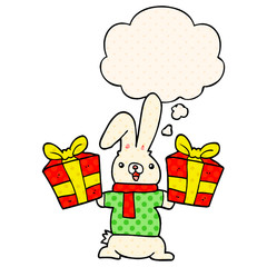 cartoon rabbit with christmas presents and thought bubble in comic book style