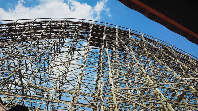 A Wooden Roller Coaster Ascending To The Peak Of Its Tallest Hill