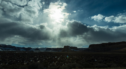 Light rays of the sun through overcast cloudy sky over Utah mountain landscape in USA