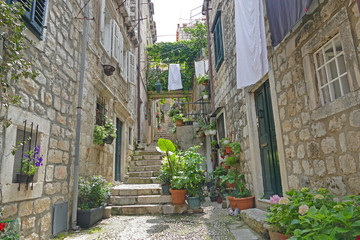 Fototapeta na wymiar Historic street with stone houses clothes line and flowers, Dubrovnik, Croatia