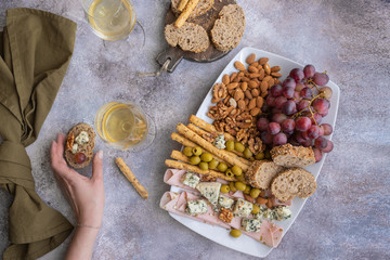 Female hand holding wine snack.Tasting party background. Top view.