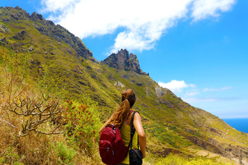 Naklejka premium Young hiker woman looking the peak of mountain thinking that much is needed to get to the top