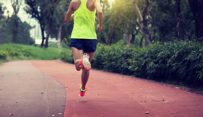 Fitness sporty woman jogger running at outdoors jogging track in park