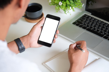 Cropped shot view of man hands holding smart phone with blank copy space screen for your text message or information content, female reading text message on cell telephone during in urban setting. 