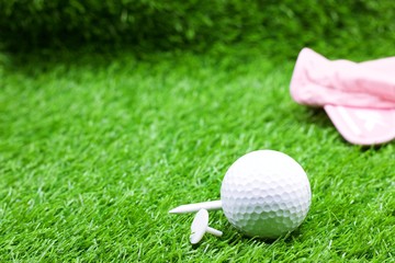 golf ball and tee on green grass