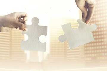two hands join together two pieces of puzzle, concept of strategy and business