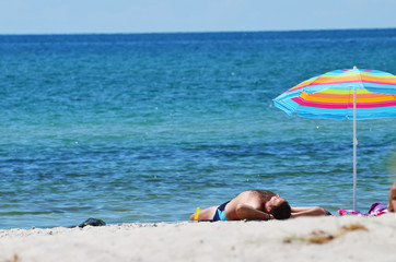 Stripped beach umbrella on the tropical beach. Relaxing summer background