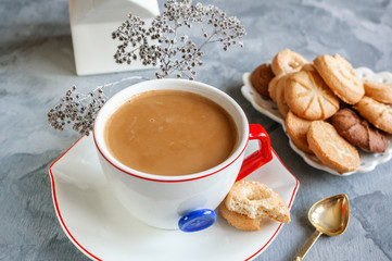 Morning hot chocolate in the original white Cup with a blue button on the background of biscuits. Invigorating Breakfast