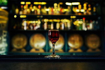 glass of red alcohol on the background of the bar