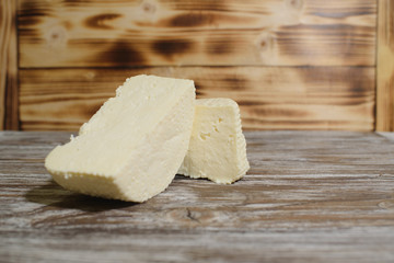 Beautiful, healthy and tasty feta cheese on a beautiful textured wooden background