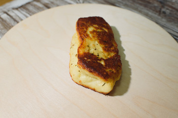Delicious, fried and healthy Halloumi cheese on a light wooden tray on a beautiful wooden background