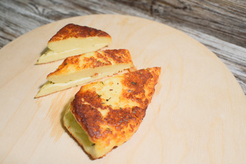 Delicious, fried and healthy Halloumi cheese on a light wooden tray on a beautiful wooden background
