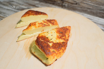 Delicious, fried and healthy Halloumi cheese on a light wooden tray on a beautiful wooden background