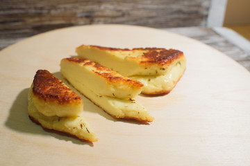 Delicious, fried and healthy Halloumi cheese on a light wooden tray on a beautiful wooden background