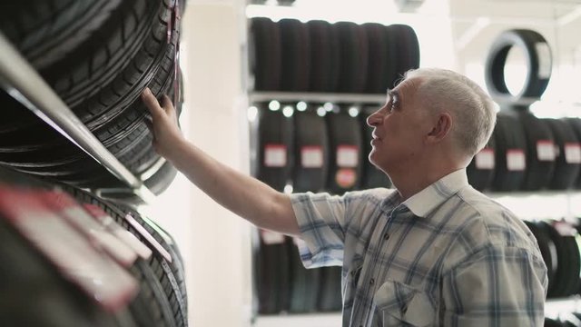 Senior man chosing new tires in shop