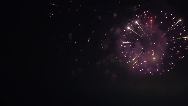 LOCKED OFF view of fireworks going off at night for party