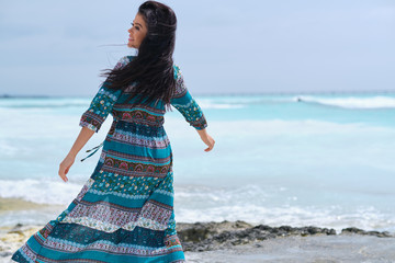 Woman in dress on beach. Young happy woman in dress on beach