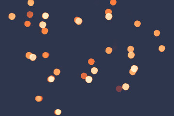 Abstract scattering of golden lights on a dark background. Tinted