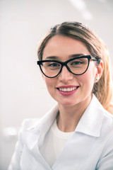 Young caucasian female dentist at the workplace in a dentistry cabinet