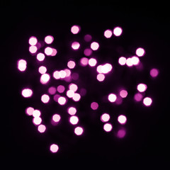 Abstraction from purple bokeh lights of hexagonal shape on black square