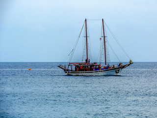 Fototapeta na wymiar A lonely touristic boat on a calm blue sea