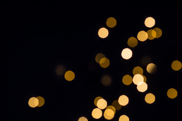 Gold bokeh lights shine. Black festive background © colnihko