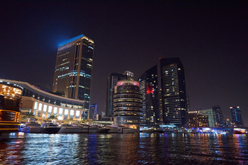 Obraz premium Dubai Marina at night with colorful touristic boats
