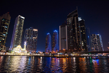 Obraz na płótnie Canvas Dubai Marina at night with colorful touristic boats