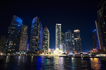 Fototapeta na wymiar Dubai Marina at night with colorful touristic boats