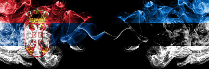 Serbia vs Estonia, Estonian smoky mystic flags placed side by side. Thick colored silky smokes combination of Serbian and Estonia, Estonian flag