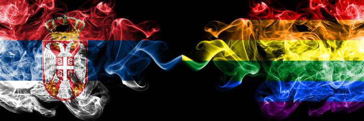Fototapeta premium Serbia vs Gay pride smoky mystic flags placed side by side. Thick colored silky smokes combination of Serbian and Gay pride flag