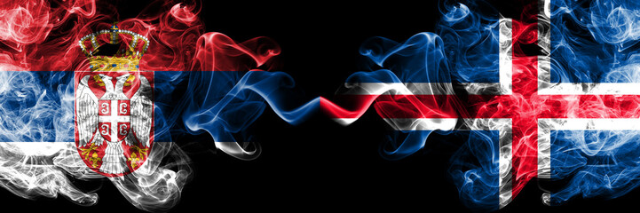 Serbia vs Iceland, Icelandic smoky mystic flags placed side by side. Thick colored silky smokes combination of Serbian and Iceland, Icelandic flag
