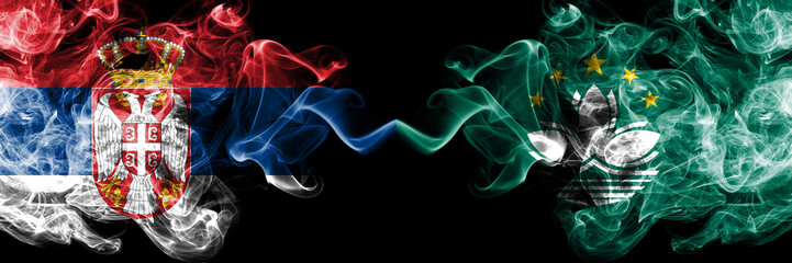 Serbia vs Macau, China smoky mystic flags placed side by side. Thick colored silky smokes combination of Serbian and Macau, China flag