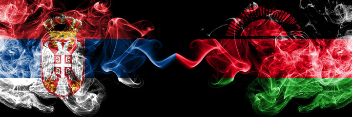 Serbia vs Malawi, Malawian smoky mystic flags placed side by side. Thick colored silky smokes combination of Serbian and Malawi, Malawian flag