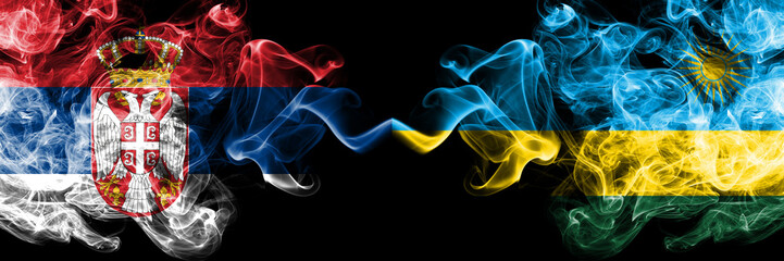 Serbia vs Rwanda, Rwandan smoky mystic flags placed side by side. Thick colored silky smokes combination of Serbian and Rwanda, Rwandan flag