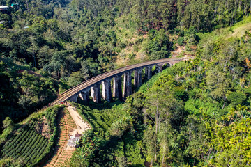 Aerial of famous nine arch bridge in Ella, Sri Lanka with blue train