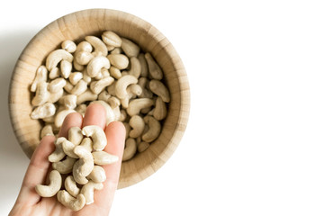cashew nuts on palm and wooden Cup with nuts, selective focus and copyspace
