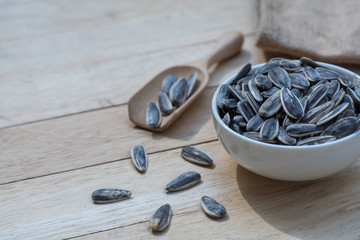 Sunflower seed, snack, in white bowl on wood table