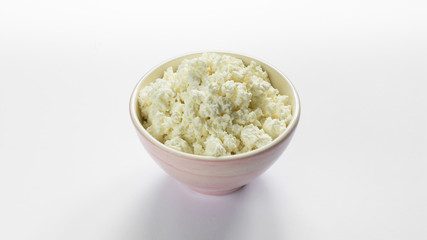 cottage cheese in a pink bowl on a white background