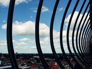 View over historic part of Groningen city under blue sky with clouds with black iron fence