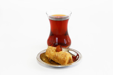 traditional Turkish sweet with baklava nuts and Turkish tea in a glass beaker