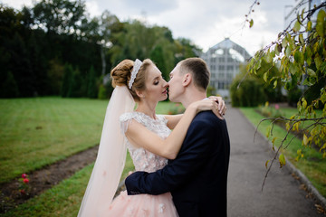 Naklejka premium Bride and groom hug in the park. Close-up