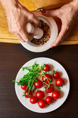 Close-up shot of woman hands grinding pepper