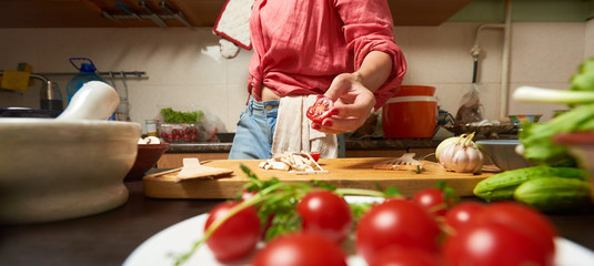 Wide shot of a woman holding cutted cherry tomato in hand © frimufilms