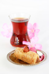 traditional Turkish sweet with baklava nuts and Turkish tea in a glass beaker