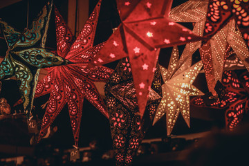 Star shaped christmas decorations hanging on a kiosk at a christmas market