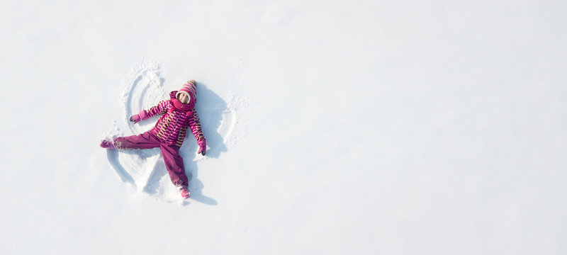 Kid making a snowangel. View from above
