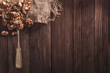 Walnuts on an old spoon and composition from old wood and material. Top view and empty space on right side for your text